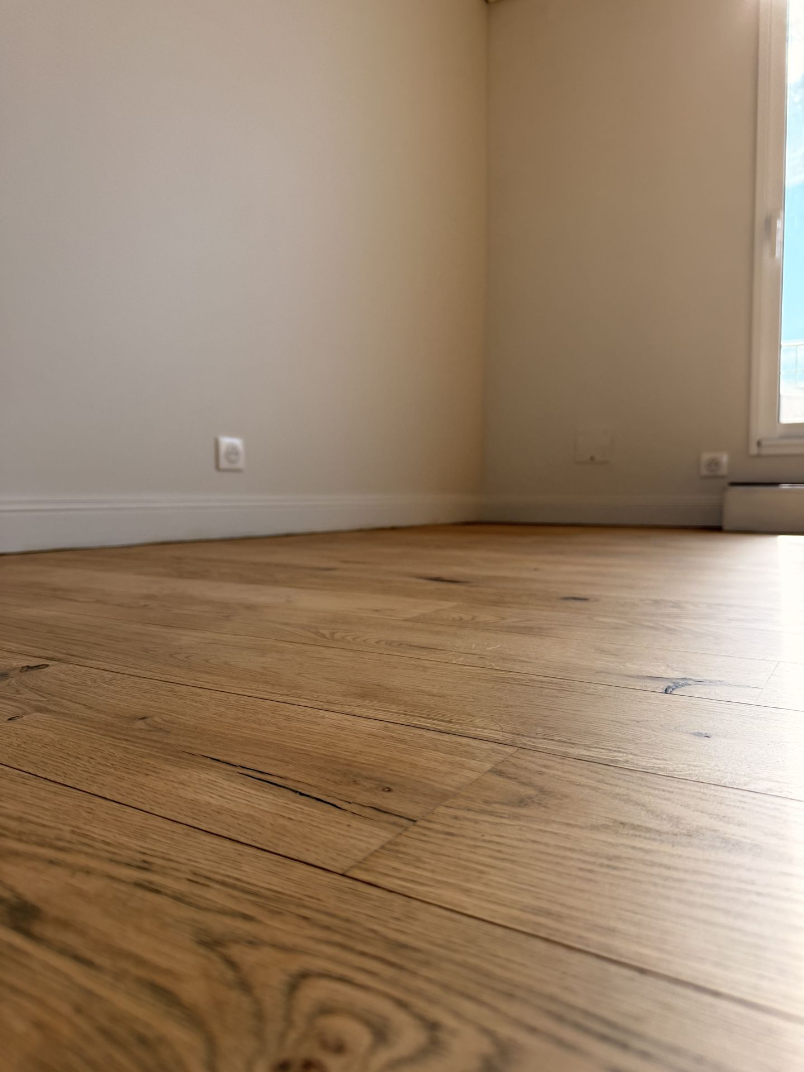 Sol à effet bois dans une pièce claire éclairée par une fenêtre.
