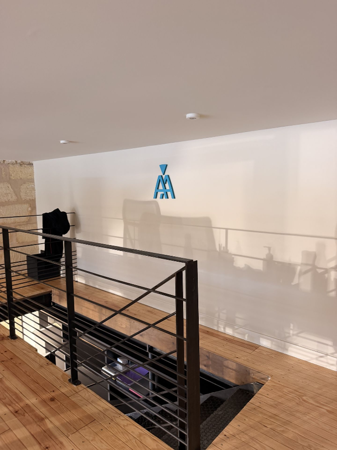 Palier de bureaux avec un garde-corps noir et un plancher en bois.