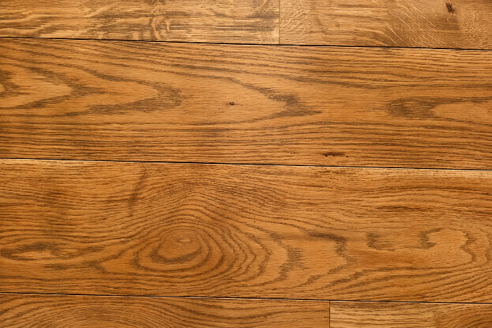 Gros plan sur un revêtement à effet bois brun et veinage prononcé.