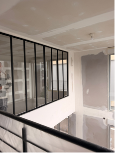 Aménagement intérieur blanc avec une verrière et une ouverture de plancher.