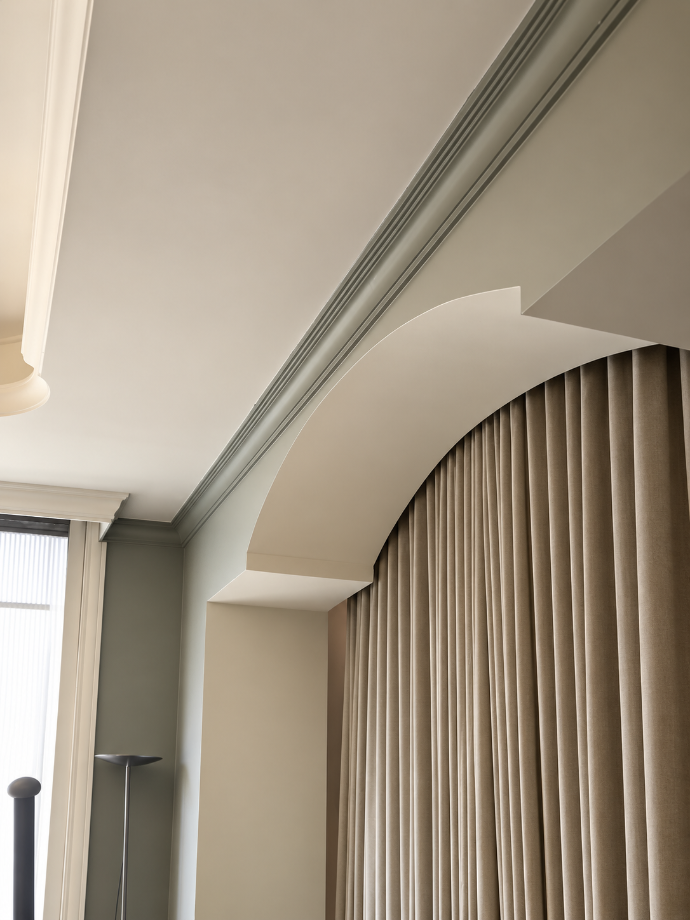 Retombée de plafond arrondie au-dessus d’un rideau.