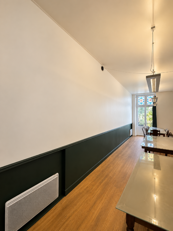 Mur bicolore avec un soubassement foncé et une cimaise horizontale.
