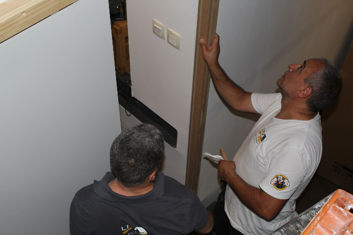 Deux artisans vérifiant un encadrement de porte intérieur.