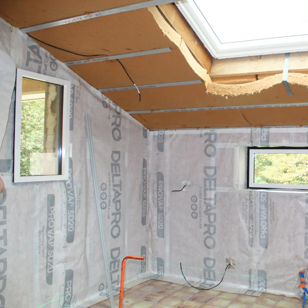 Isolant et membrane de protection apparents autour d’une fenêtre de toit.