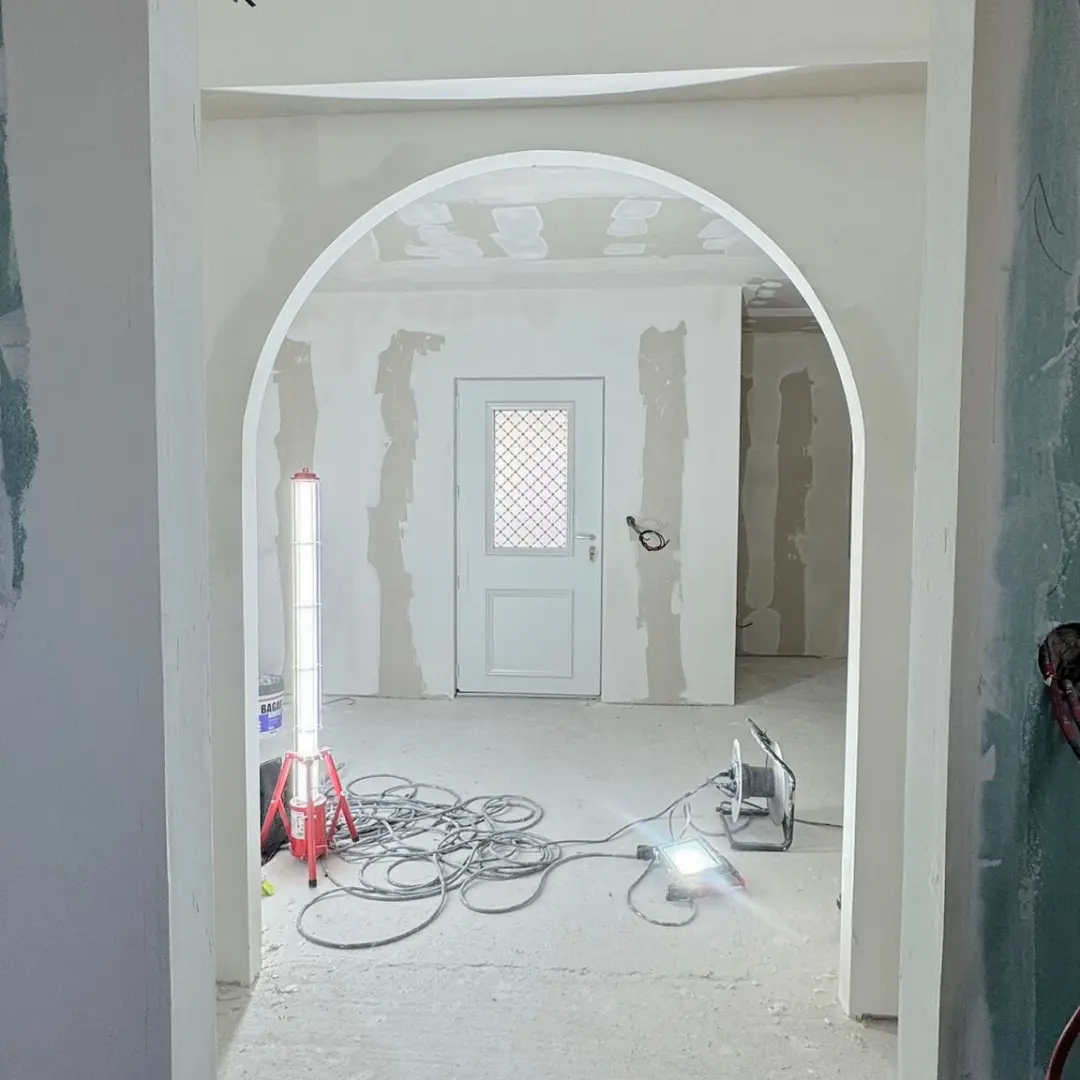 Arche intérieure jointoyée ouvrant sur une entrée en travaux.