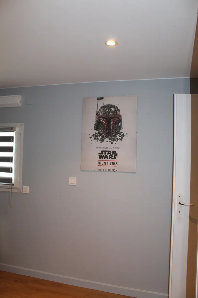 Mur gris clair et plafond blanc dans une pièce meublée.