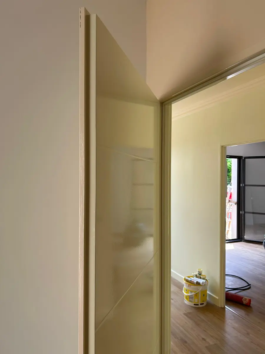 Passage intérieur avec un encadrement arrondi et une pièce en travaux à l’arrière-plan.