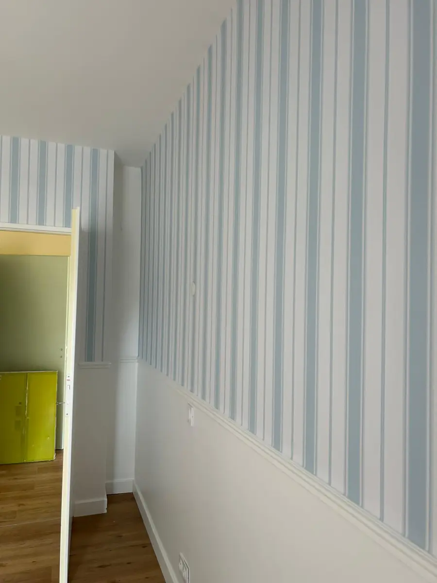 Mur à rayures bleues et blanches avec un soubassement blanc.