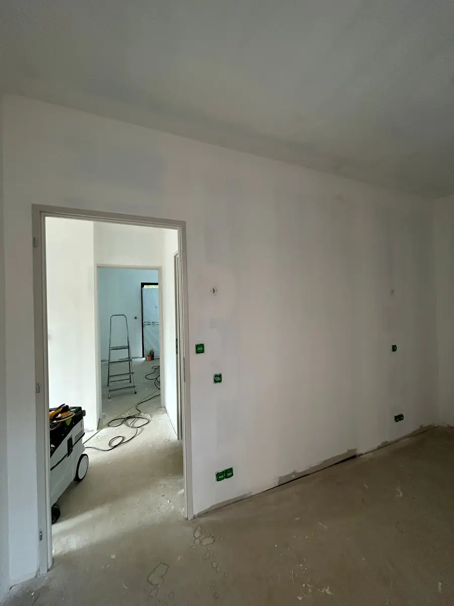 Mur préparé autour d’une ouverture de porte avant peinture.