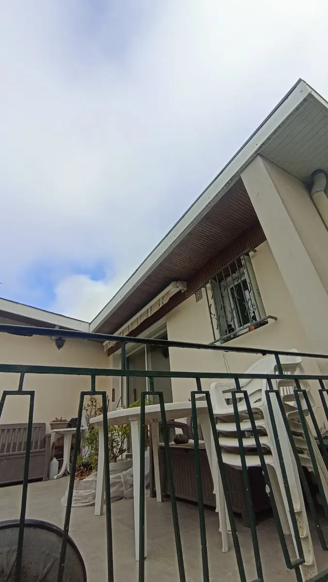 Terrasse d’une maison avec des reprises visibles sur les murs extérieurs.
