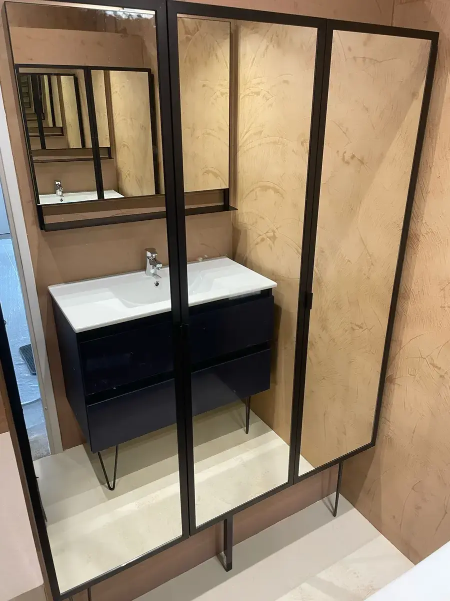 Salle de bain à verrière noire avec un meuble vasque et des murs beiges nuancés.