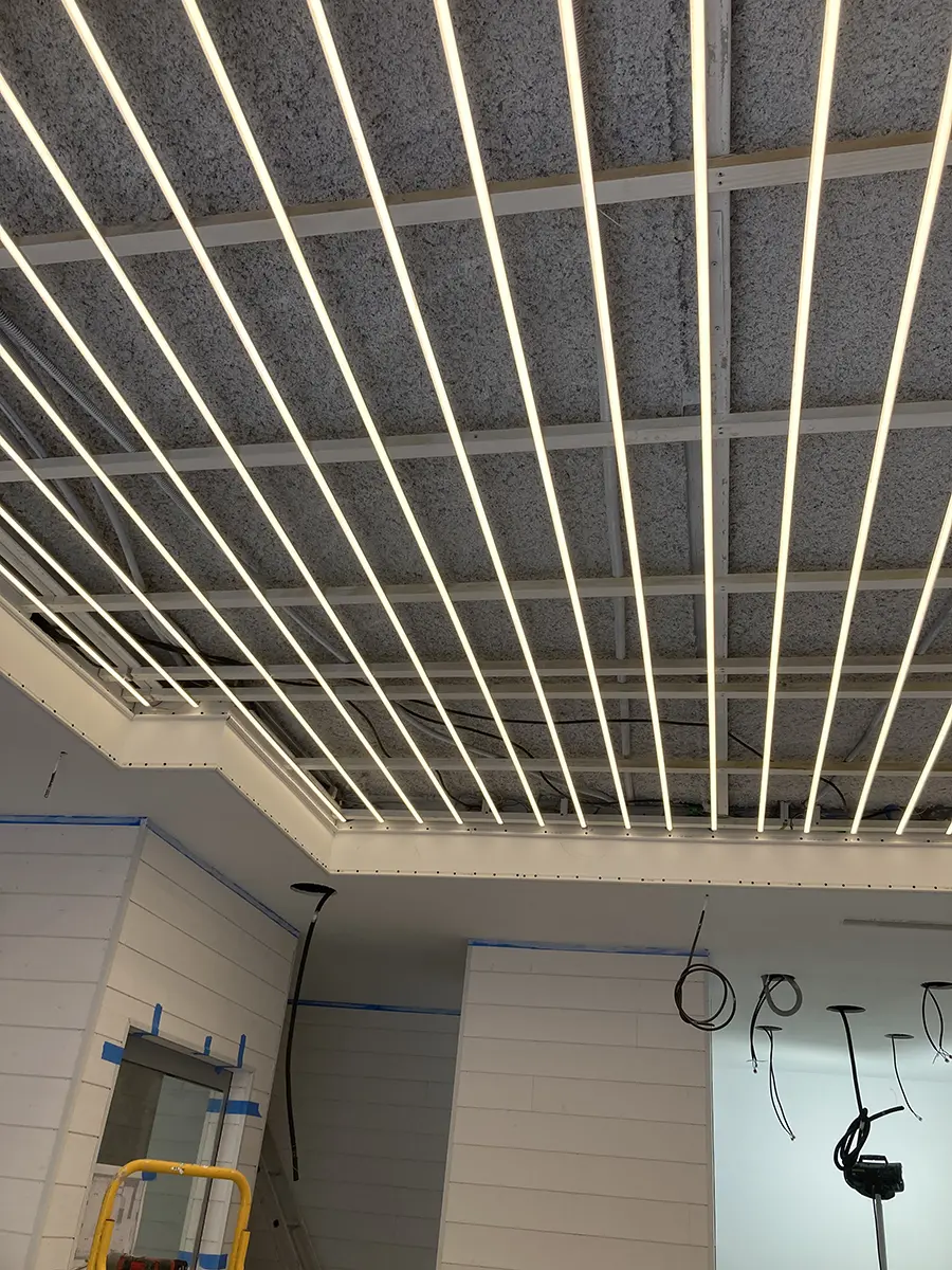 Ossature de plafond apparente au-dessus d’un commerce en travaux.
