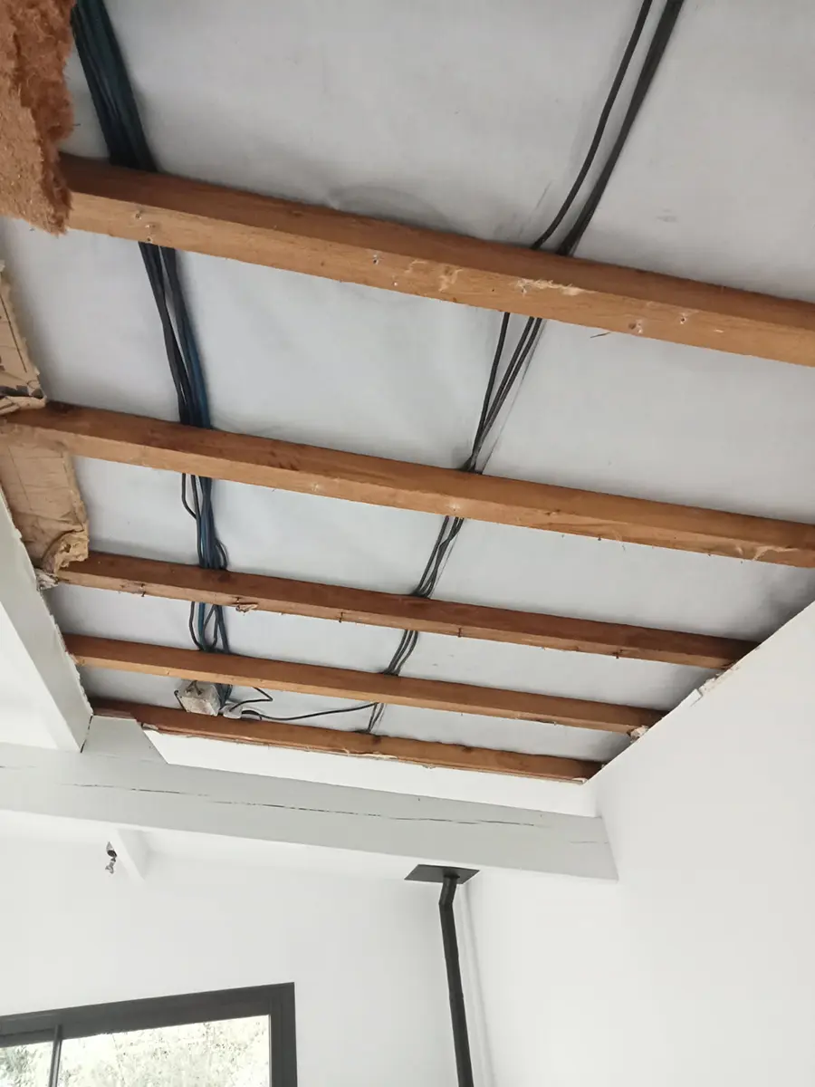 Solives et réseaux apparents dans un plafond en cours de rénovation.