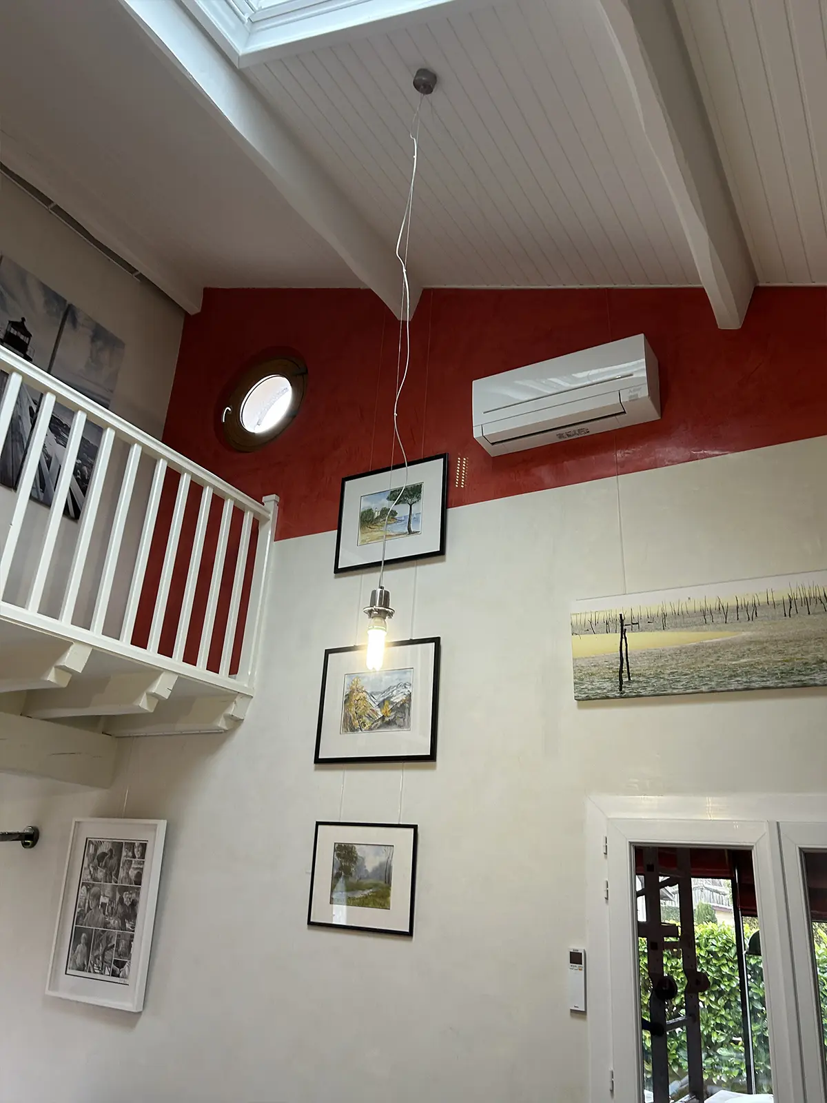 Vue de l’espace sous mezzanine avec un mur rouge et des garde-corps blancs.
