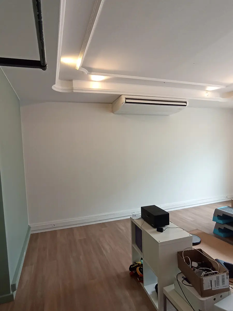 Pièce de consultation avec un plafond à éclairage indirect et une climatisation murale.