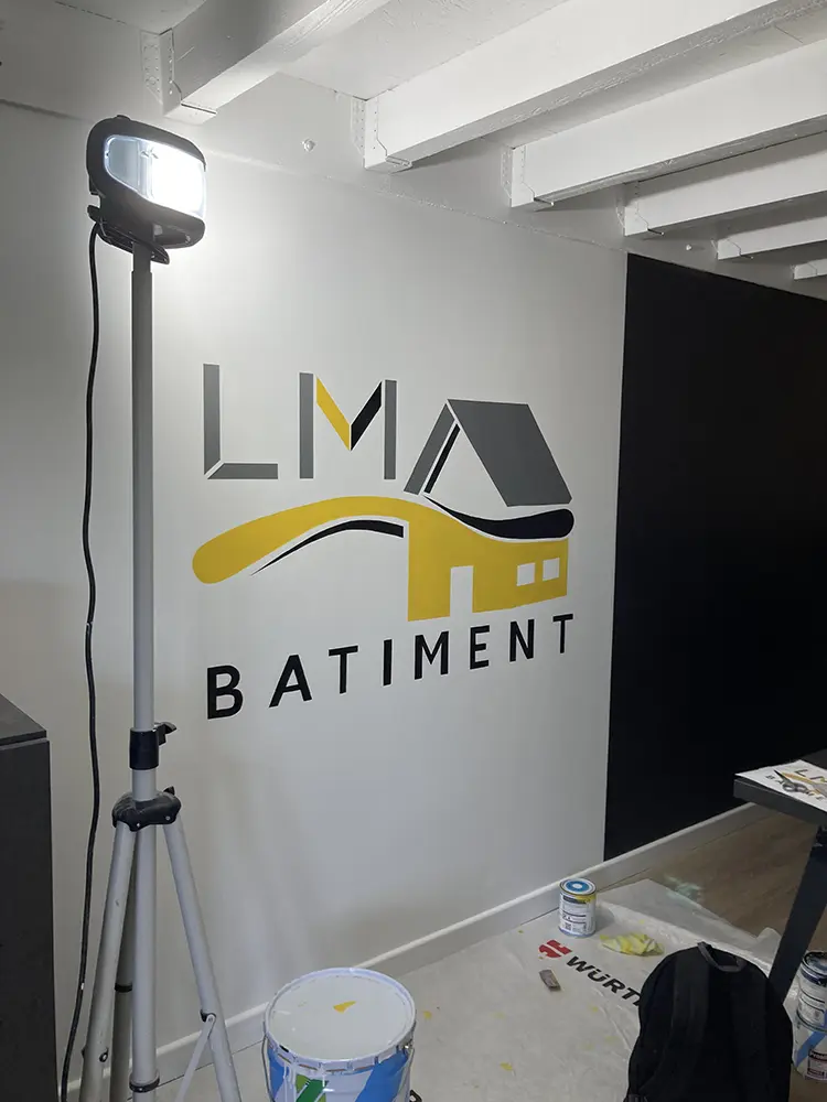 Logo LM Bâtiment terminé sur un mur de bureau.