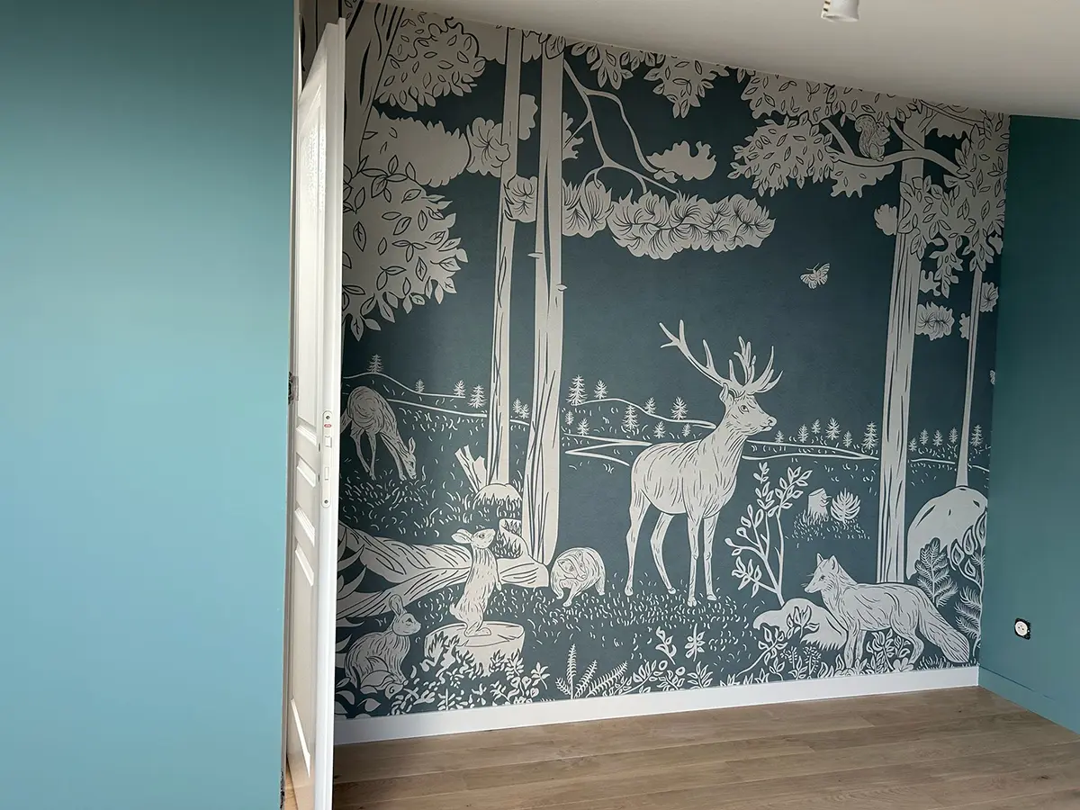 Papier peint panoramique à motifs de végétation et de cerfs sur fond bleu-vert.