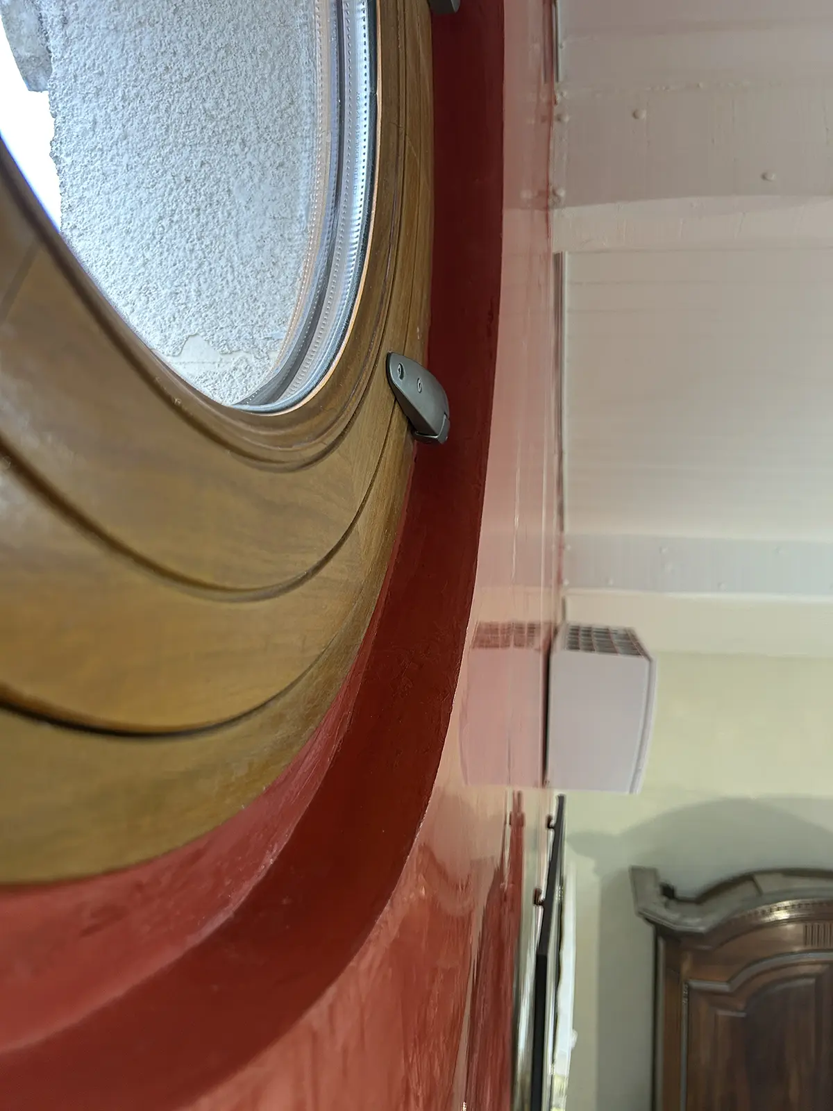Encadrement d’une fenêtre ronde avec des protections de peinture.
